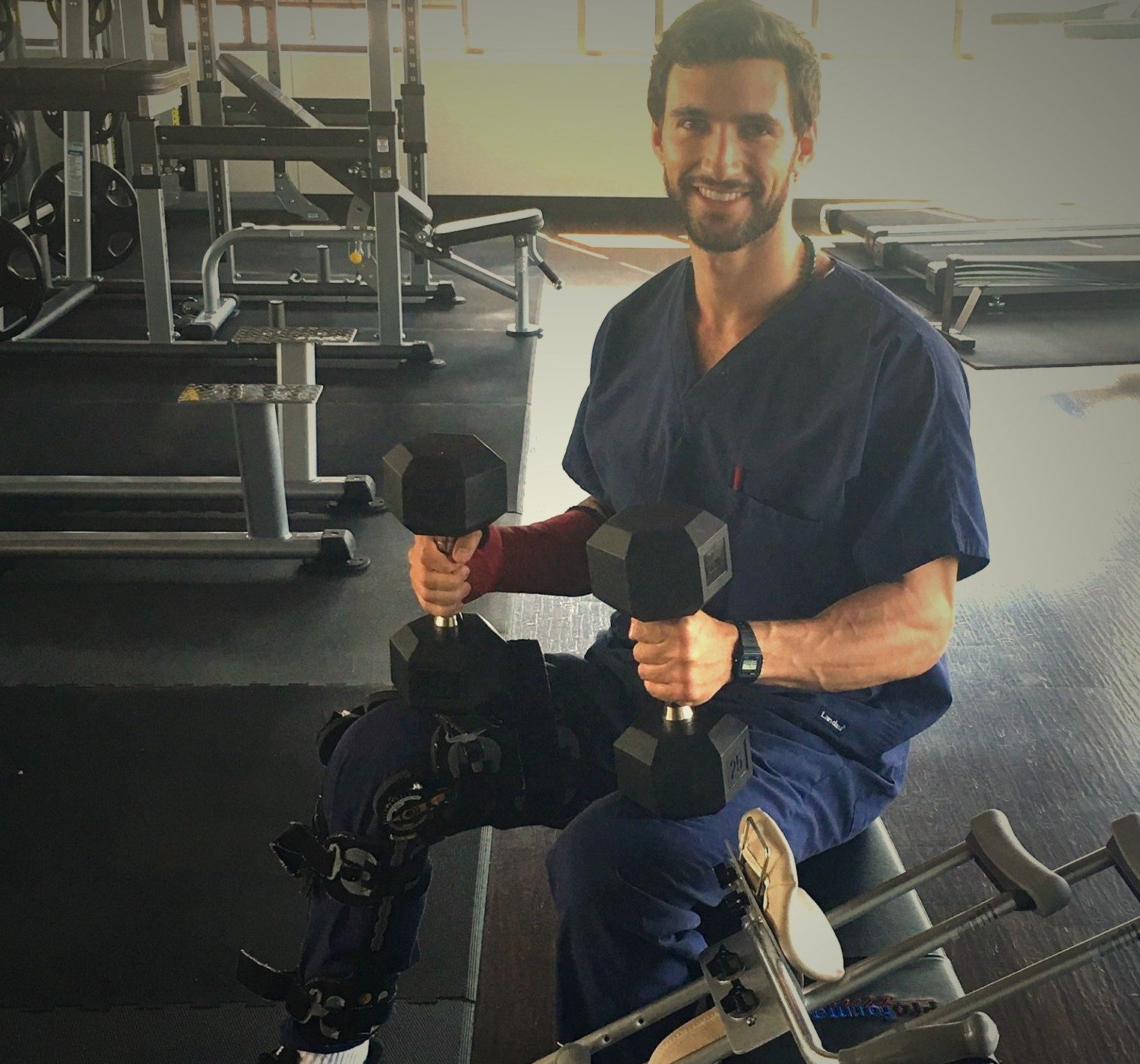 Anthony training through recovery in medical scrubs with a leg brace